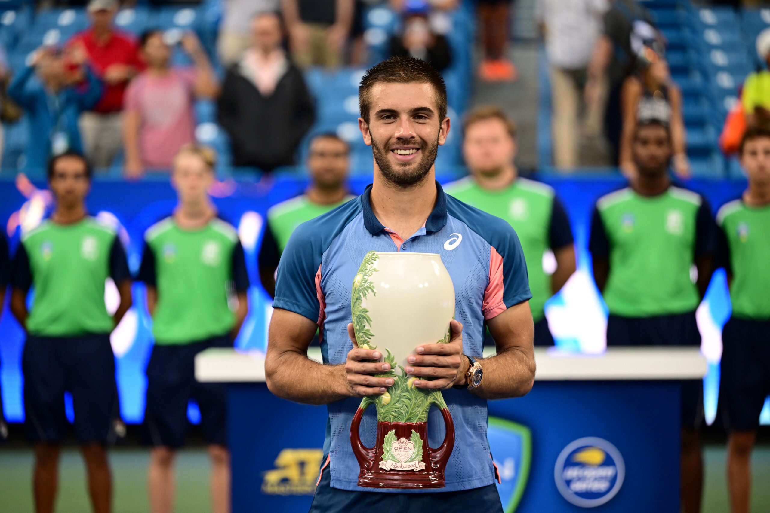 Borna Coric holding men's singles championship trophy on center court
