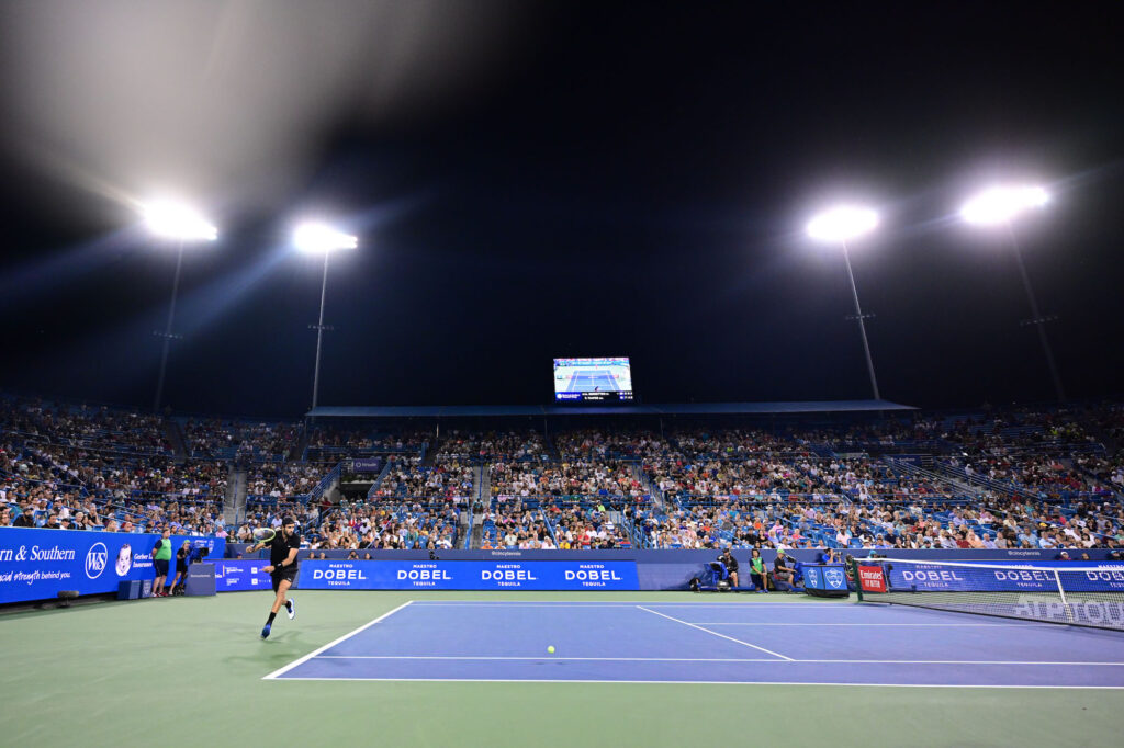 fans in the stands with a match at night