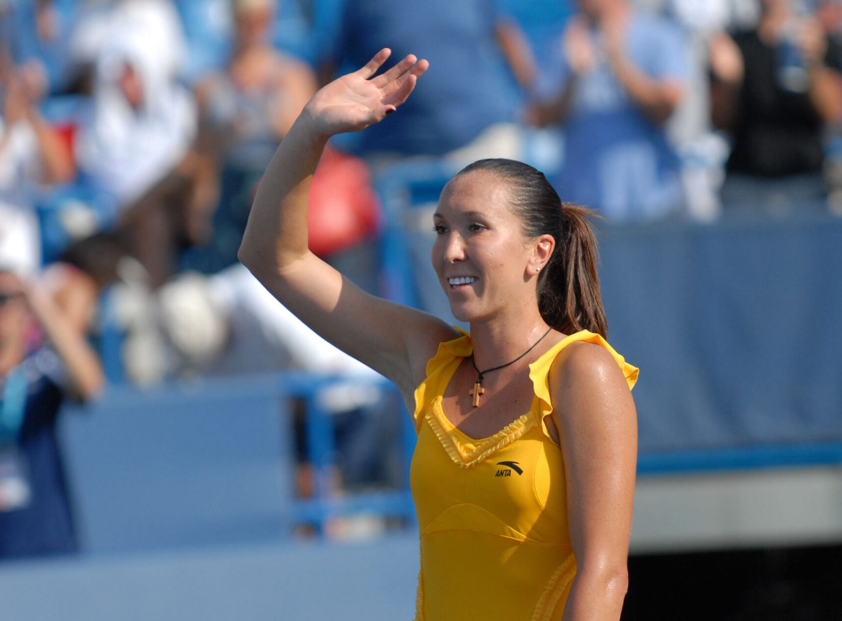 woman waving at tennis stadium