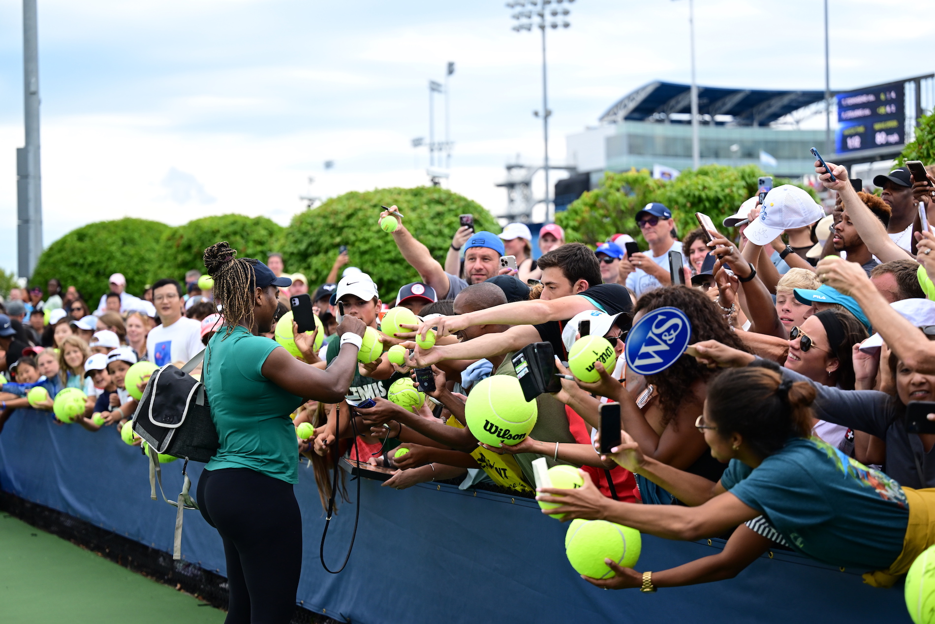 woman signing fans tennis balls