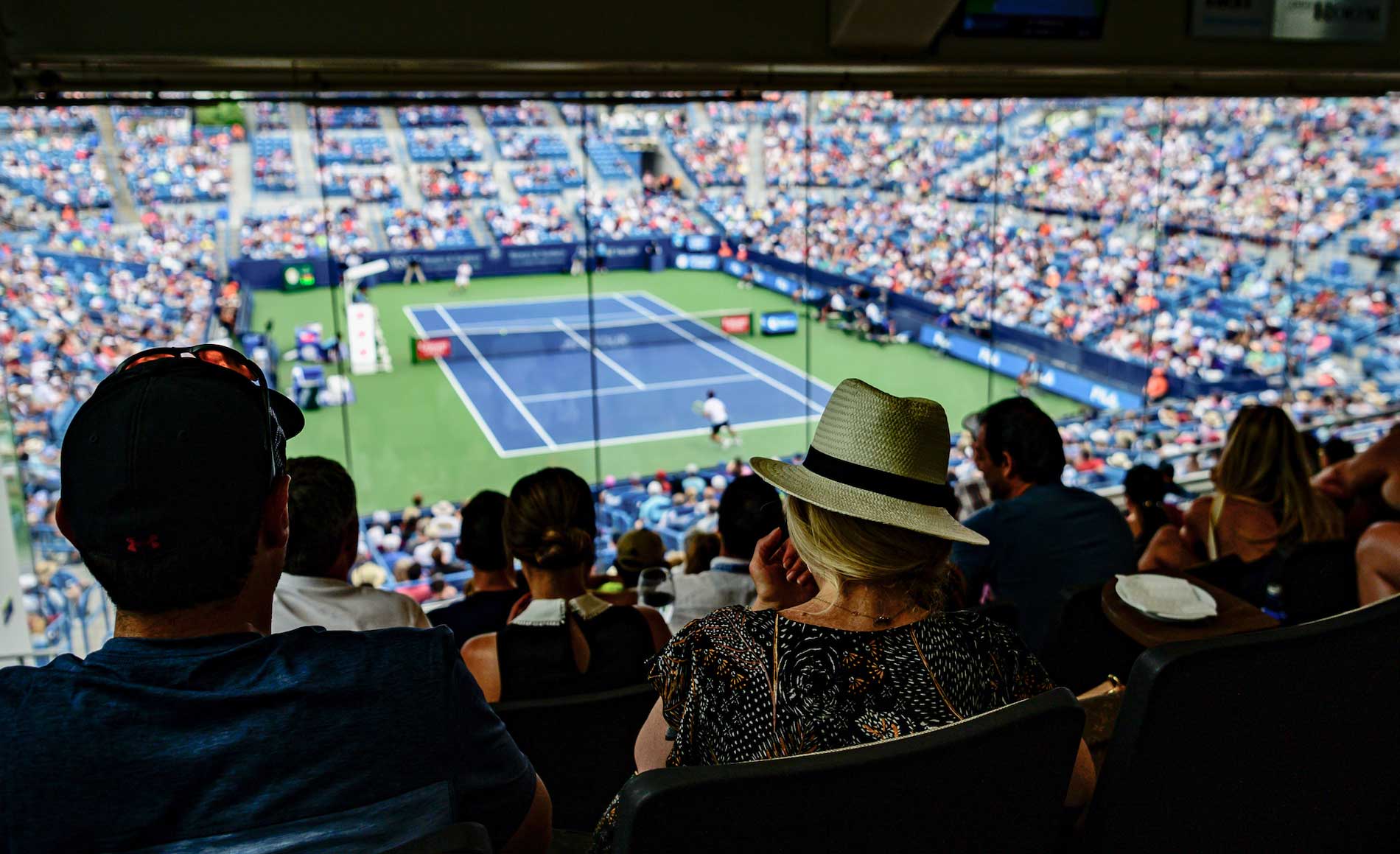 fans watching tennis from box seating