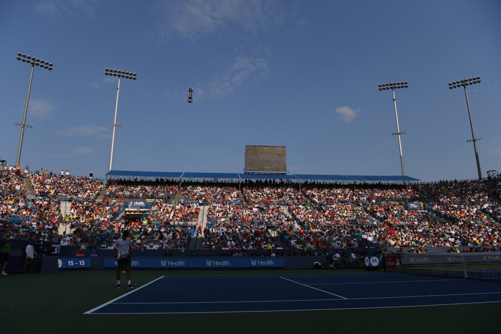A wide shot of the crowd watching Djokovic preparing to serve