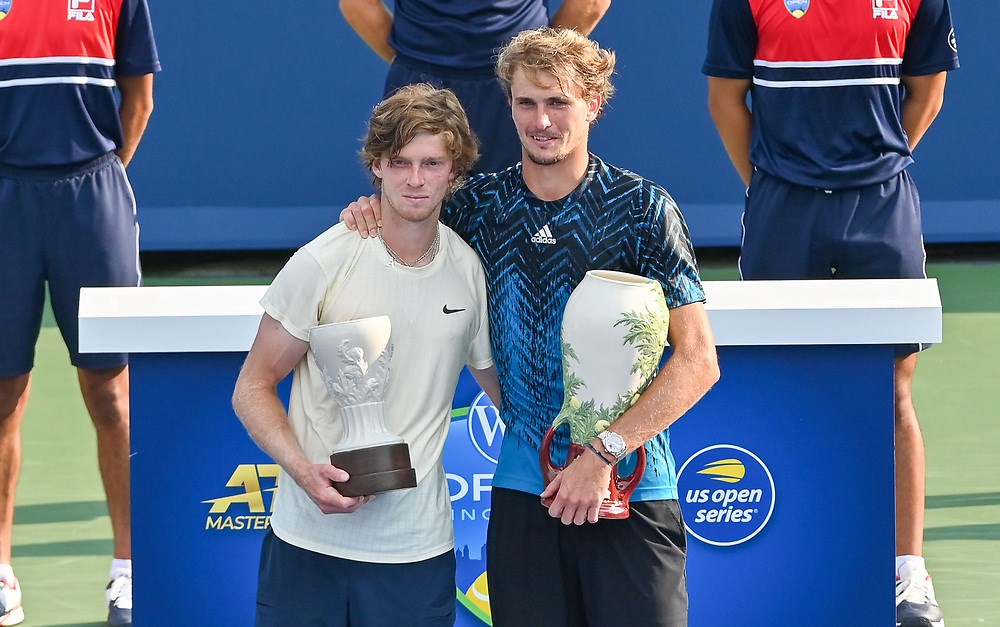 two men posing with trophies