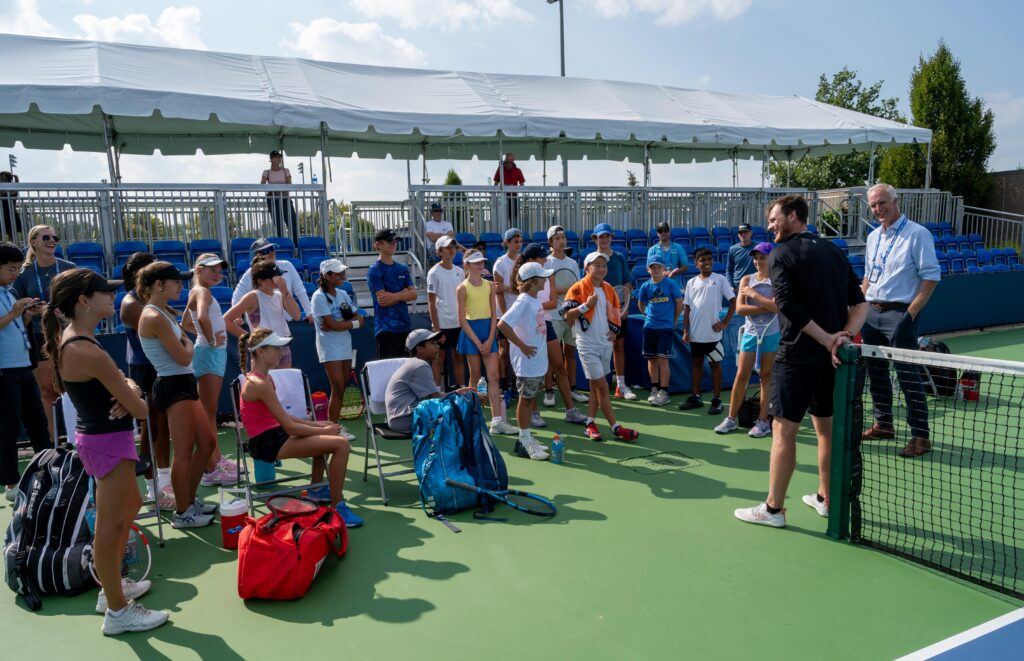 Todd Martin and Michael Venus talk to a group of kids